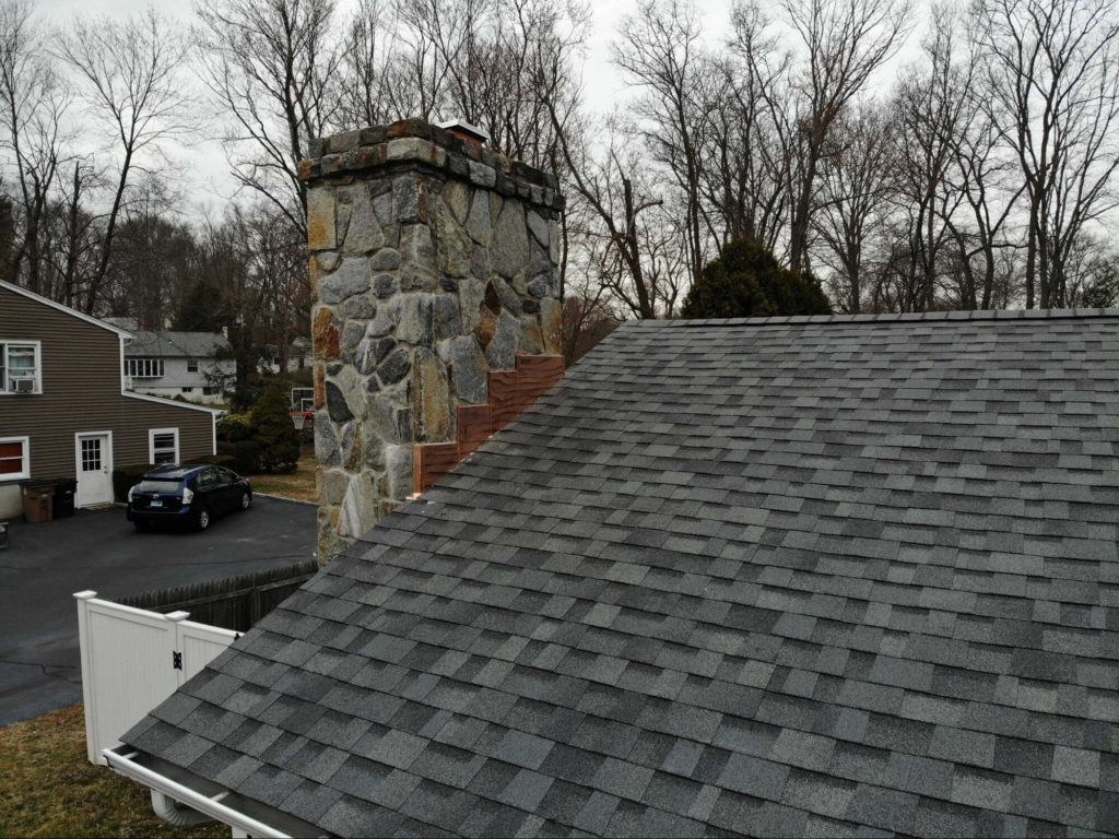 Rooftop with asphalt shingles and chimney with copper flashing